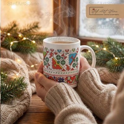 Зимен уют: Ръце държат топла чаша с шарена българска бродерия