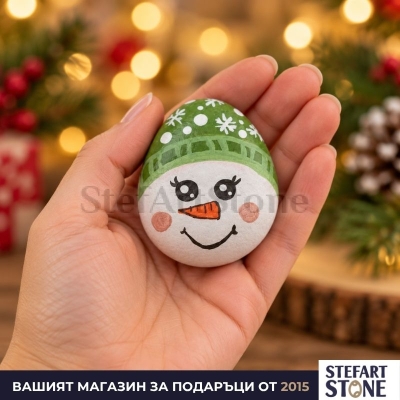 Ръчно рисуван камък снежен човек в ръка